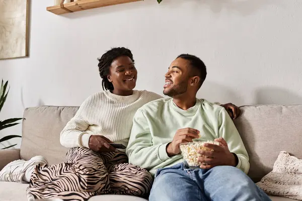 Una coppia felice si gode la compagnia in un'accogliente notte d'inverno condividendo popcorn. — Foto stock