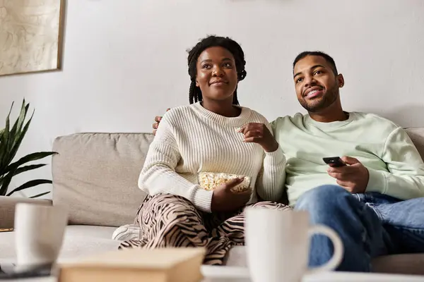 Una coppia felice si gode il tempo di qualità insieme in una serata invernale, condividendo risate e spuntini. — Foto stock