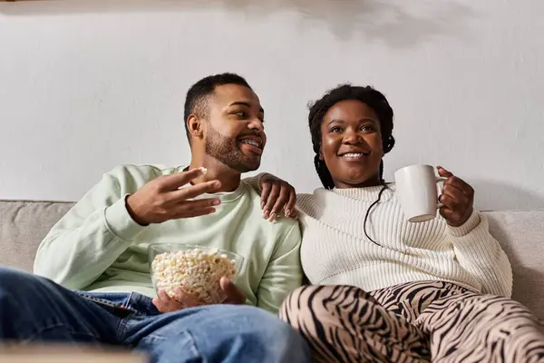 Un paio condividono popcorn e caffè, godendosi reciprocamente la compagnia in una giornata invernale. — Foto stock