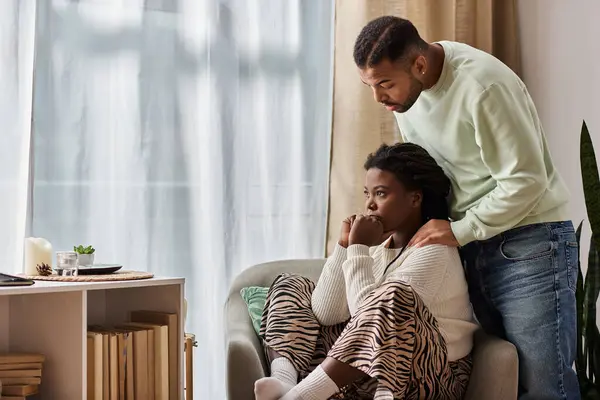 Afro-Américain réconfortant sa triste petite amie dans leur salon confortable — Photo de stock