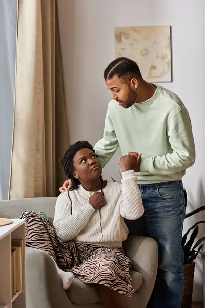 Afro-américain homme réconfortant sa petite amie dans leur salon confortable — Photo de stock