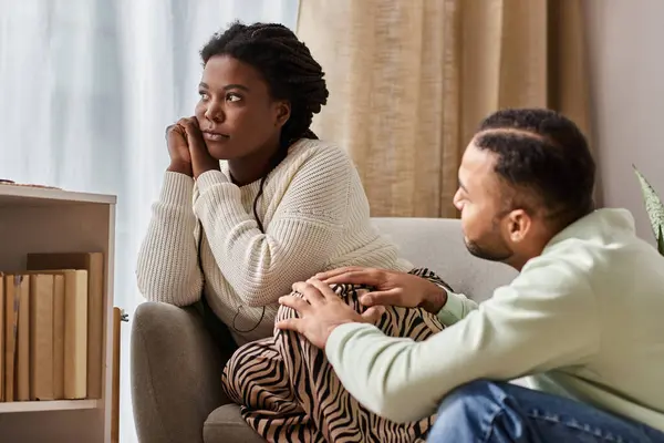 Afro-Américain regardant sa petite amie inquiète dans leur salon confortable — Photo de stock