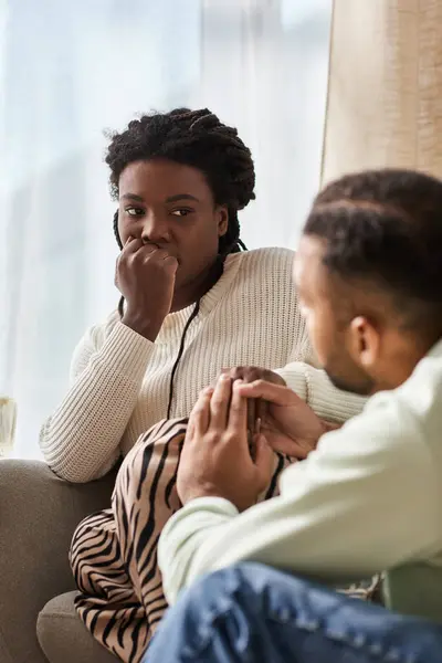 Afro-américain homme tenant la main de sa petite amie inquiète dans leur salon confortable — Photo de stock