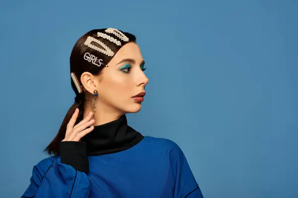 A stylish young woman showcases modern fashion with striking hair clips and bold makeup. — Stock Photo
