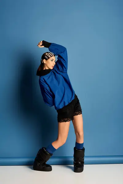 A fashionable young woman poses confidently in a striking blue outfit with stylish hair clips. — Stock Photo