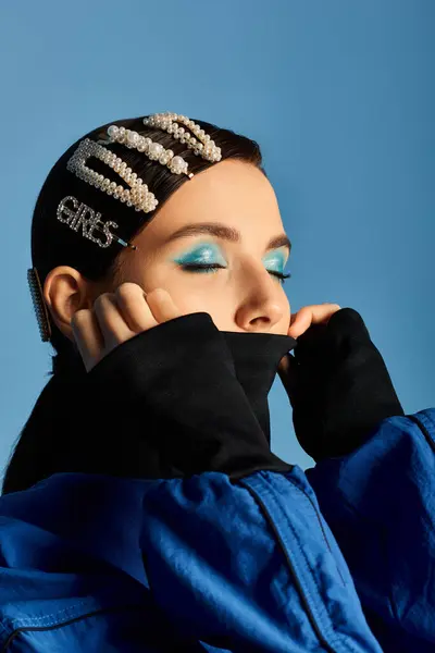 A stylish young woman poses with elegant hair clips, showcasing vibrant attire in a studio. — Stock Photo