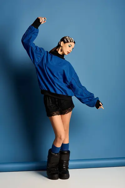 Stylish woman poses confidently in chic attire, showcasing contemporary fashion in studio. — Stock Photo
