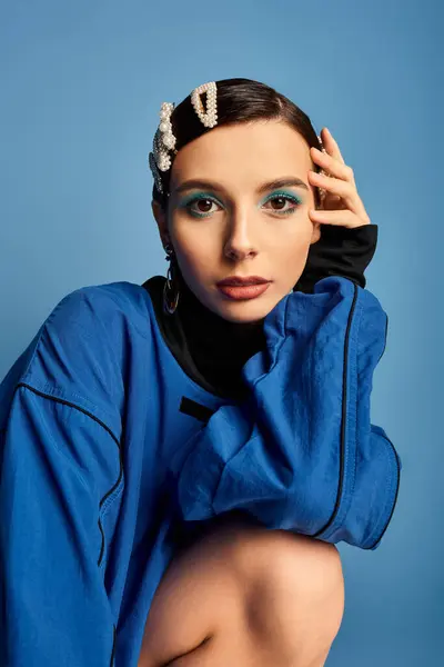 Young woman showcases trendy attire with hair clips while posing in a stylish studio setting. — Stock Photo