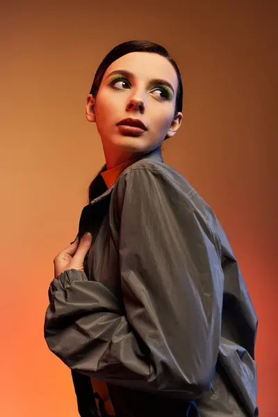 A fashionable young woman showcases her trendy outfit while posing gracefully in a studio setting. — Stock Photo