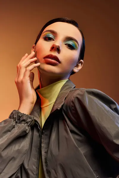 Уверенная в себе молодая женщина демонстрирует свой триумфальный наряд и поразительный макияж в современной студии. — стоковое фото