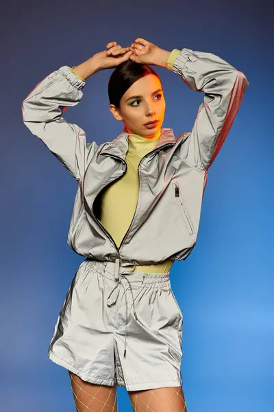A pretty young woman showcases her trendy outfit while confidently posing in a studio setting. — Stock Photo