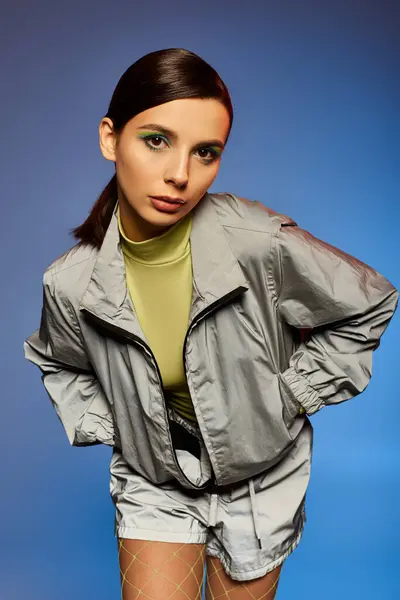 Une jeune femme élégante pose avec confiance dans des vêtements à la mode sur un fond vibrant. — Photo de stock