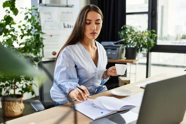Beautiful brunette reflects thoughtfully while jotting down notes in her stylish workspace. — Stock Photo