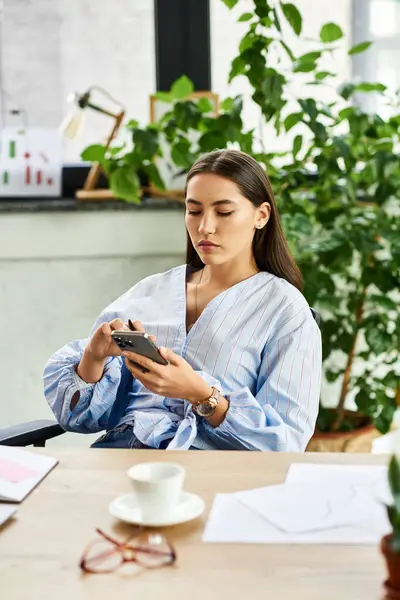 Beautiful brunette woman sits thoughtfully, relaxing in a bright, plant filled office. — Stock Photo
