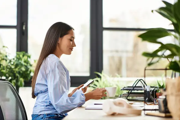 Young woman relaxes with a cup while engaged in her work at a bright and airy workspace. — Stock Photo