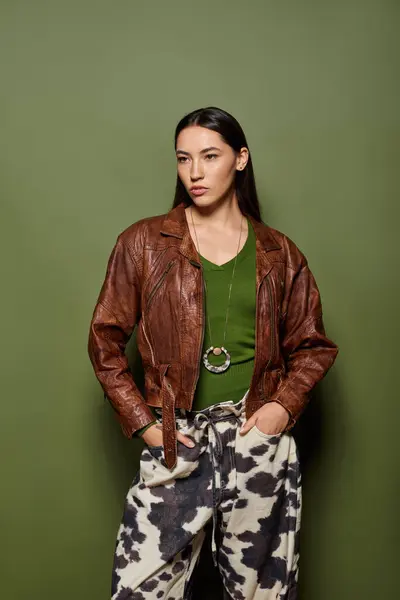 Beautiful woman showcases her fashion sense with confidence while standing against a green wall — Stock Photo