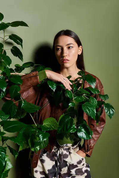 Elegant young brunette stands confidently, connecting with nature in a contemporary space. — Stock Photo