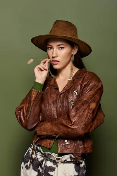 Mujer morena exuda estilo y confianza, posando en una chaqueta de cuero de moda y sombrero. — Stock Photo