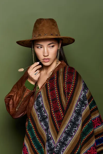 Brunette woman dressed in colorful traditional clothing holds a brush and gazes pensively. — Stock Photo