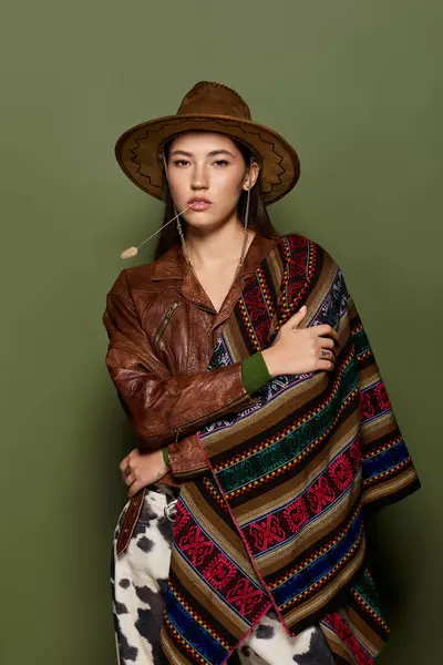 A young brunette woman flaunts her style in a vibrant outfit and hat, looking serious. — Stock Photo