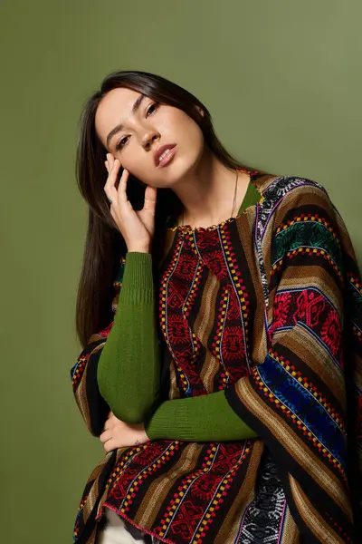 A beautiful young woman poses confidently while wearing a vibrant poncho, embracing her style. — Stock Photo