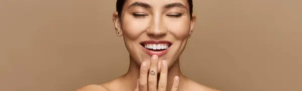 Brunette woman beams with joy, showcasing a bright smile against a neutral background. — Stock Photo
