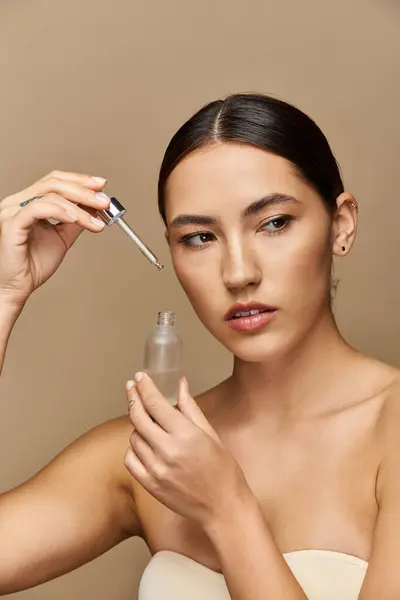 Eine junge Brünette trägt Serum auf und verbessert mühelos ihren strahlenden Hautglanz. — Stockfoto