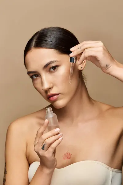 Charming brunette applies nourishing serum while showcasing flawless skin in a calming space. — Stock Photo