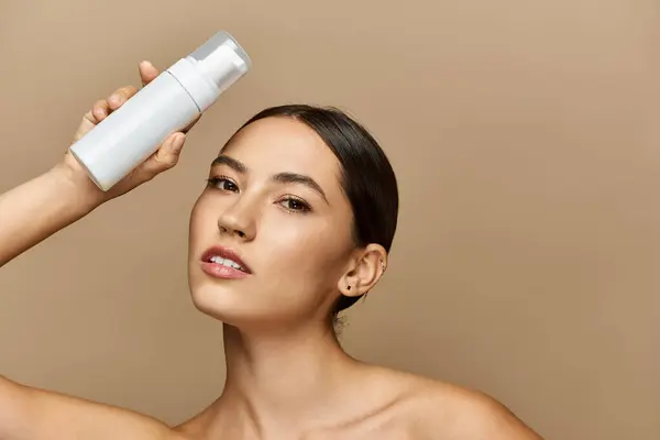 Joyful brunette woman applies skincare product with confidence in a stylish, modern environment. — Stock Photo