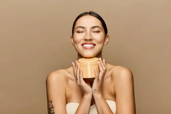 A beautiful young woman embraces skincare, radiating joy with her closed eyes and glowing smile. — Stock Photo
