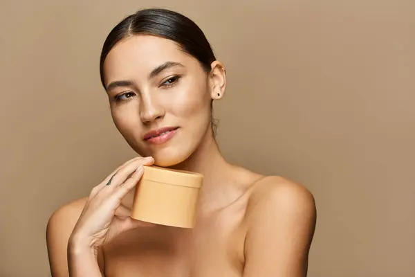 Young woman enjoys promoting her skincare essentials with poise and radiant charm. — Stock Photo