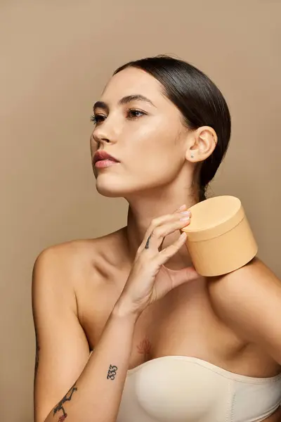 Confident young woman showcases natural skincare in a calm, elegant setting. — Stock Photo