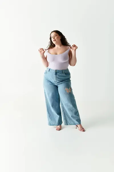 Woman in chic outfit poses with confidence against a simple backdrop, embodying modern style. — Fotografia de Stock