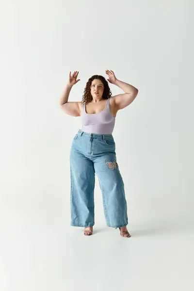 Young woman showcases her fashion confidence in trendy attire against a neutral background. — Stock Photo