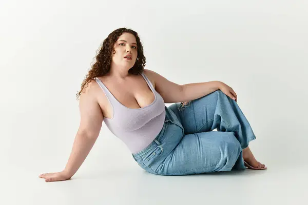 A confident woman showcases her style against a seamless background. — Stock Photo