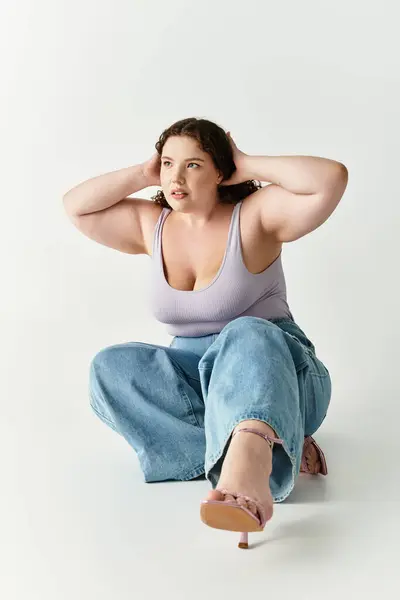 Stylish young woman poses gracefully against a light background, expressing fashion confidence. — Stock Photo