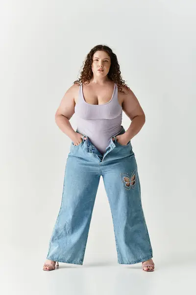 Young woman embraces her fashion sense with a trendy outfit in a minimalistic studio backdrop. — Stock Photo