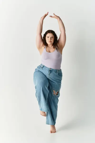 Junge Frau präsentiert ihren einzigartigen Sinn für Mode mit einer selbstbewussten Pose in einem minimalistischen Raum. — Stockfoto
