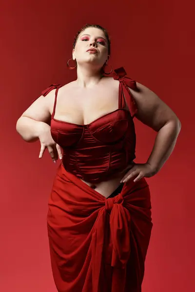 Confident young woman in red outfit poses creatively, highlighting her unique fashion. — Stock Photo