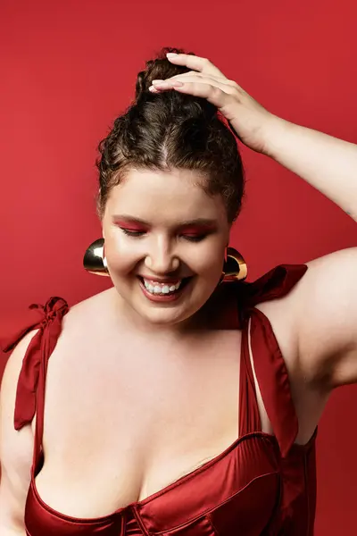 Uma mulher elegante em uma roupa vermelha chique alegremente posa para a câmera, irradiando confiança. — Fotografia de Stock