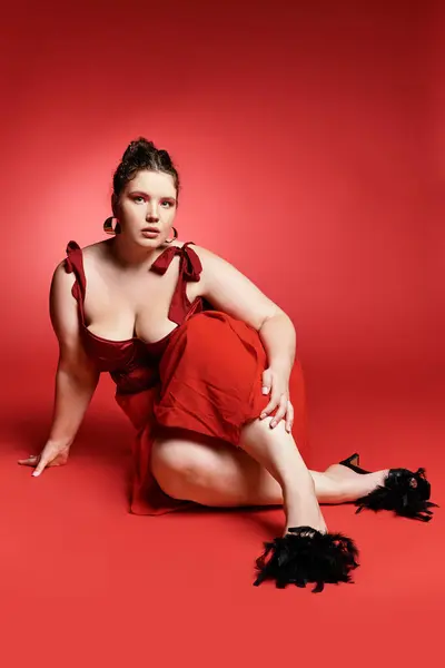 Confident young woman in a striking red dress showcases modern fashion trends. — Stock Photo
