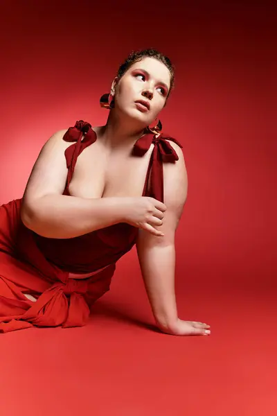 Una joven mujer destaca su estilo de moda en un llamativo traje rojo, posando con gracia. - foto de stock