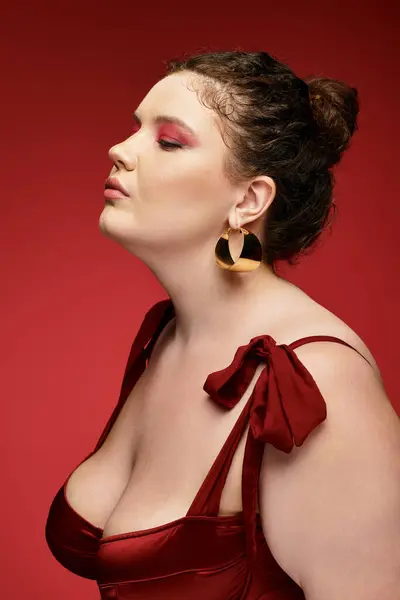 Young woman poses elegantly, highlighting her fashionable attire in a striking red backdrop. — Stock Photo