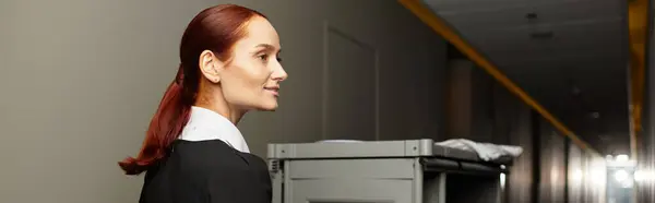 Mulher bonita em um uniforme caminha confiantemente por um corredor do hotel. — Fotografia de Stock