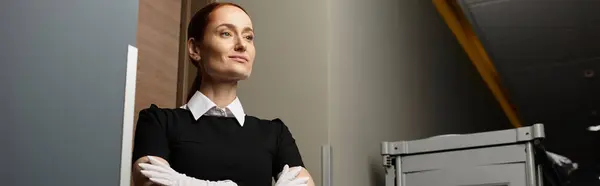 Mujer joven con aplomo se levanta con confianza en un entorno contemporáneo con iluminación suave. — Stock Photo