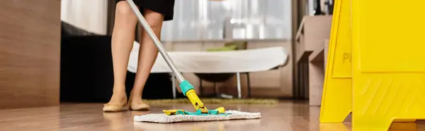 Beautiful woman mops the floor in a stylish living room filled with natural light — Stock Photo