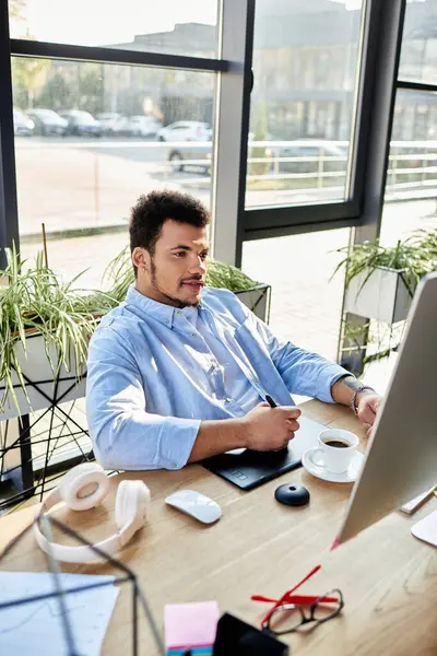 Confident man focuses on his work at a modern desk, enjoying coffee in a sunlit space. — Stock Photo