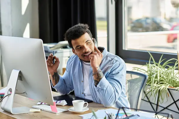 Handsome man focuses intently while working at a stylish desk surrounded by greenery. — Stock Photo