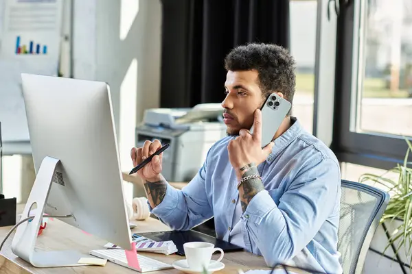 Focused individual multitasking with a phone and computer in a contemporary workspace. — Stock Photo