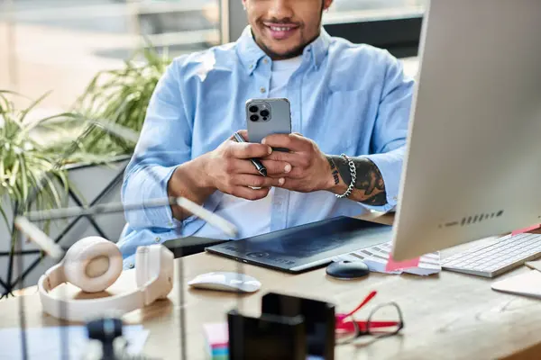 A handsome man focuses on his smartphone amidst a bright, stylish workspace. — Stock Photo